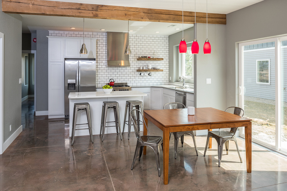 Inspiration for a mid-sized rustic l-shaped concrete floor open concept kitchen remodel in Other with a single-bowl sink, recessed-panel cabinets, white cabinets, white backsplash, stainless steel appliances, an island and subway tile backsplash