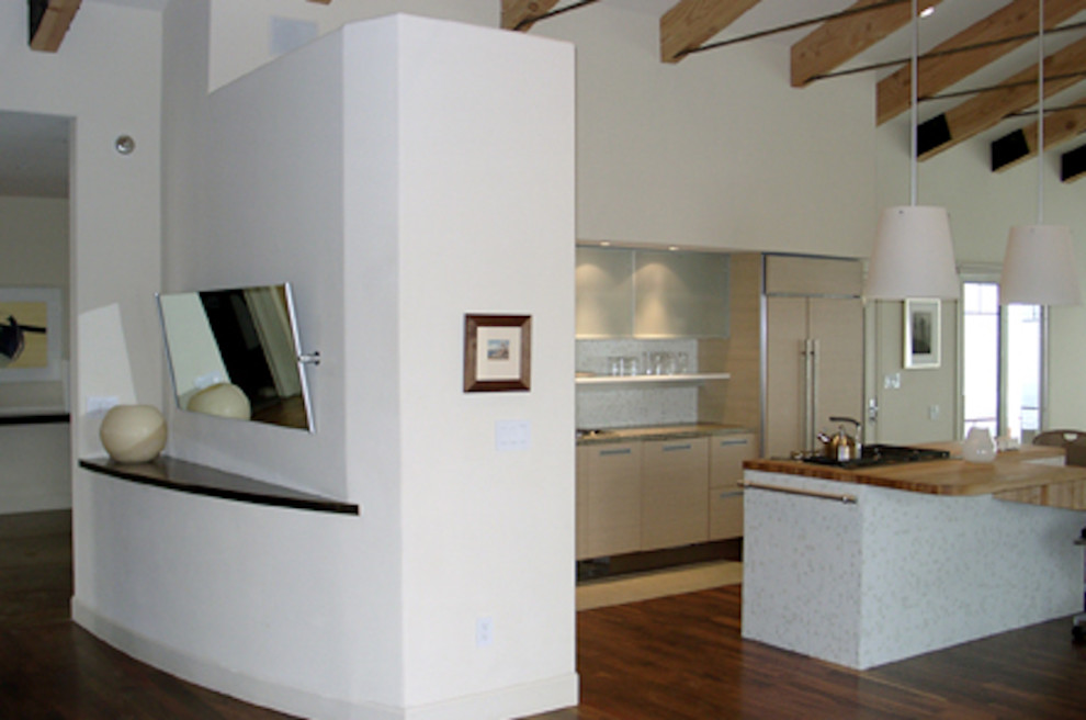 Exemple d'une cuisine ouverte encastrable tendance en L et bois clair de taille moyenne avec un placard à porte plane, un plan de travail en granite, une crédence blanche, une crédence en carreau de verre, un sol en bois brun et îlot.