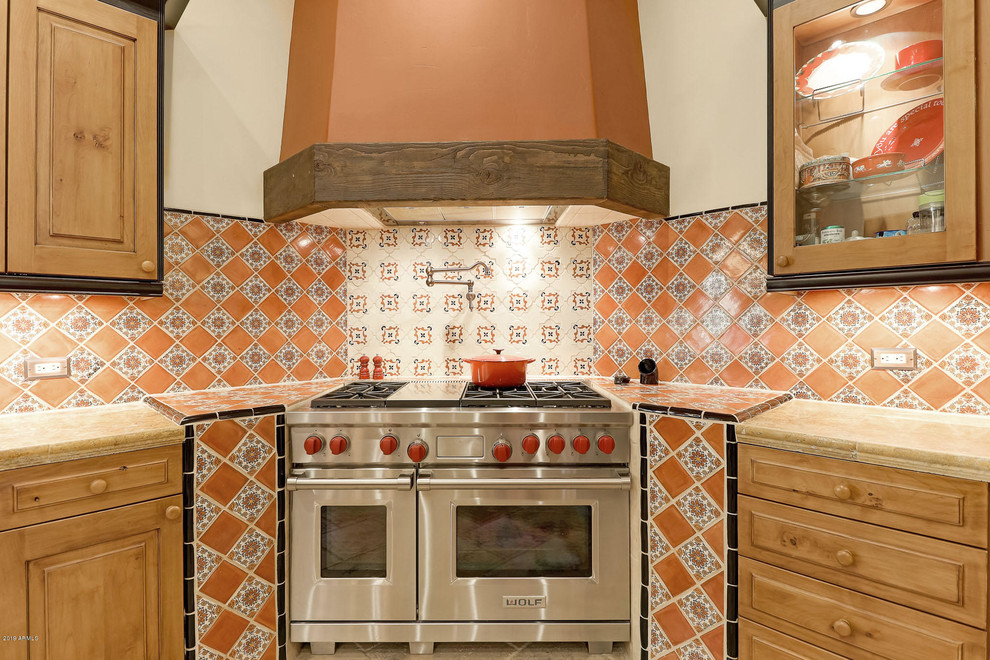 Große Mediterrane Küche in U-Form mit hellbraunen Holzschränken, Granit-Arbeitsplatte, bunter Rückwand, Küchengeräten aus Edelstahl, Kücheninsel und beiger Arbeitsplatte in Phoenix