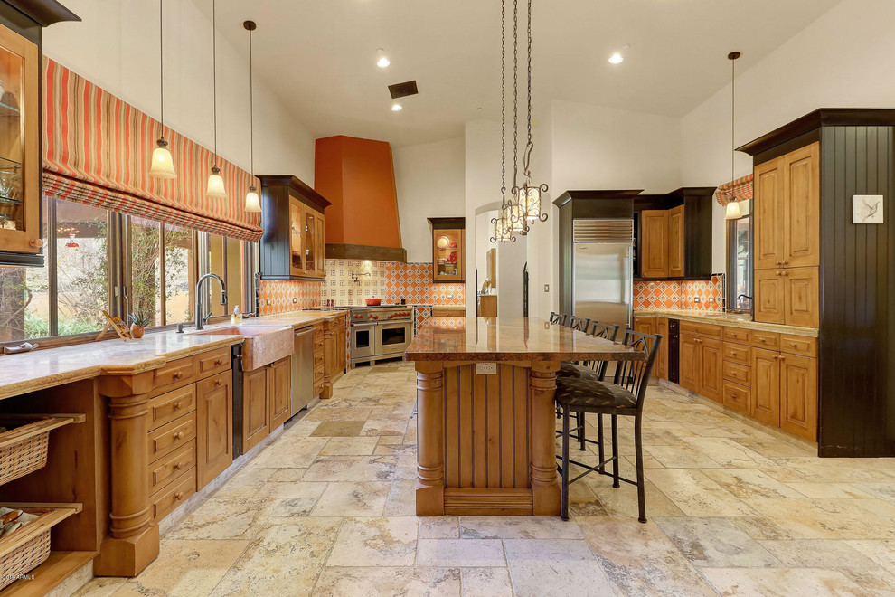 Exemple d'une grande cuisine sud-ouest américain en U et bois brun avec un plan de travail en granite, une crédence multicolore, un électroménager en acier inoxydable, îlot et un plan de travail beige.