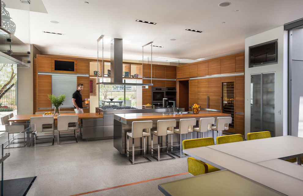 Inspiration for a large contemporary kitchen/diner in Las Vegas with an integrated sink, flat-panel cabinets, medium wood cabinets, stainless steel worktops, integrated appliances and multiple islands.