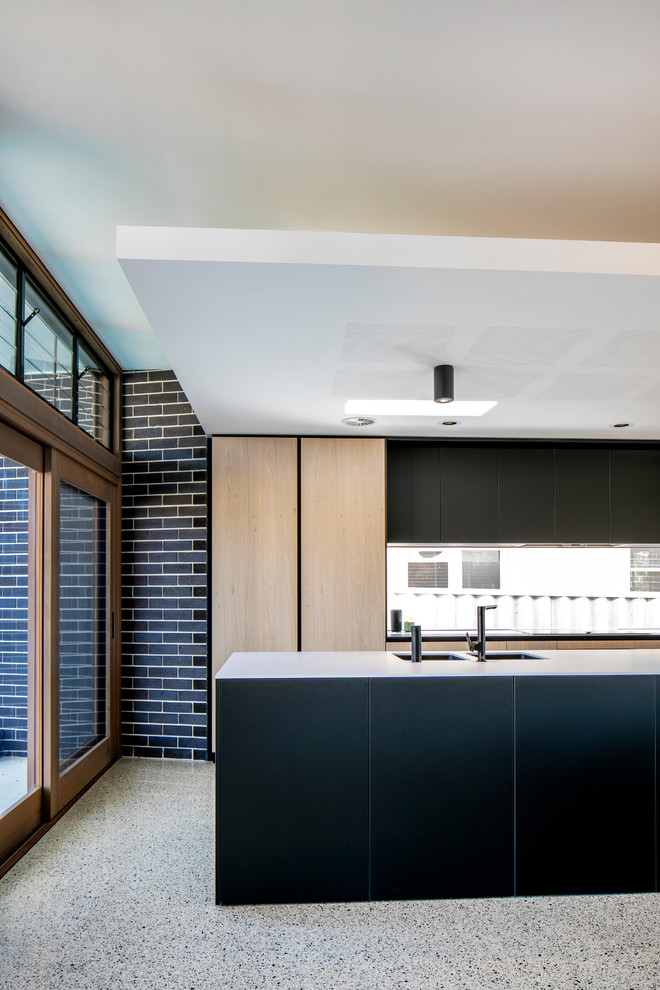 Пример оригинального дизайна: параллельная кухня среднего размера в современном стиле с обеденным столом, врезной мойкой, светлыми деревянными фасадами, фартуком из стекла, техникой из нержавеющей стали, бетонным полом и островом