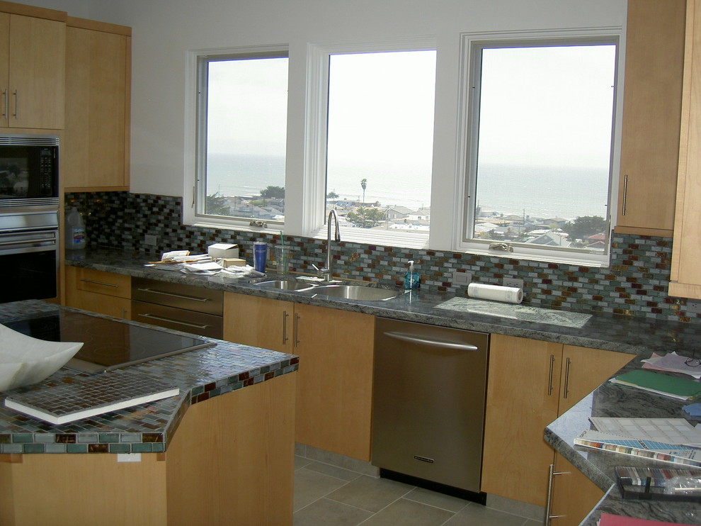 Exempel på ett mellanstort modernt kök, med en dubbel diskho, släta luckor, skåp i ljust trä, kaklad bänkskiva, flerfärgad stänkskydd, stänkskydd i stickkakel, rostfria vitvaror, klinkergolv i keramik och en köksö