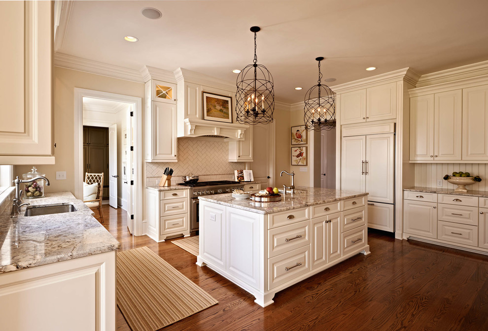 Example of a classic u-shaped kitchen design in Charlotte with an undermount sink, raised-panel cabinets, beige cabinets, beige backsplash and paneled appliances