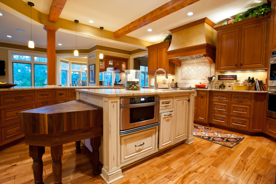 Exempel på ett klassiskt kök, med en undermonterad diskho, luckor med upphöjd panel, skåp i mellenmörkt trä, granitbänkskiva, beige stänkskydd, stänkskydd i keramik och integrerade vitvaror