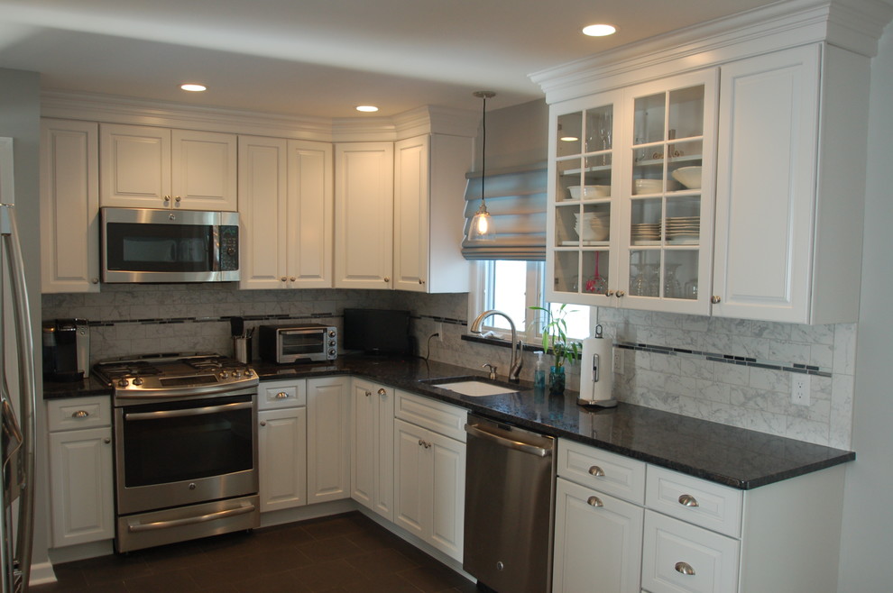 Eat-in kitchen - mid-sized traditional l-shaped ceramic tile and brown floor eat-in kitchen idea in Newark with an undermount sink, white cabinets, subway tile backsplash, stainless steel appliances, raised-panel cabinets, granite countertops, gray backsplash and no island