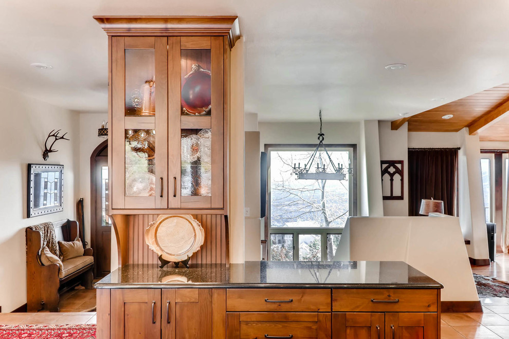 This is an example of a large rustic kitchen/diner in Denver with a submerged sink, flat-panel cabinets, dark wood cabinets, granite worktops, beige splashback, mosaic tiled splashback, stainless steel appliances, dark hardwood flooring and an island.