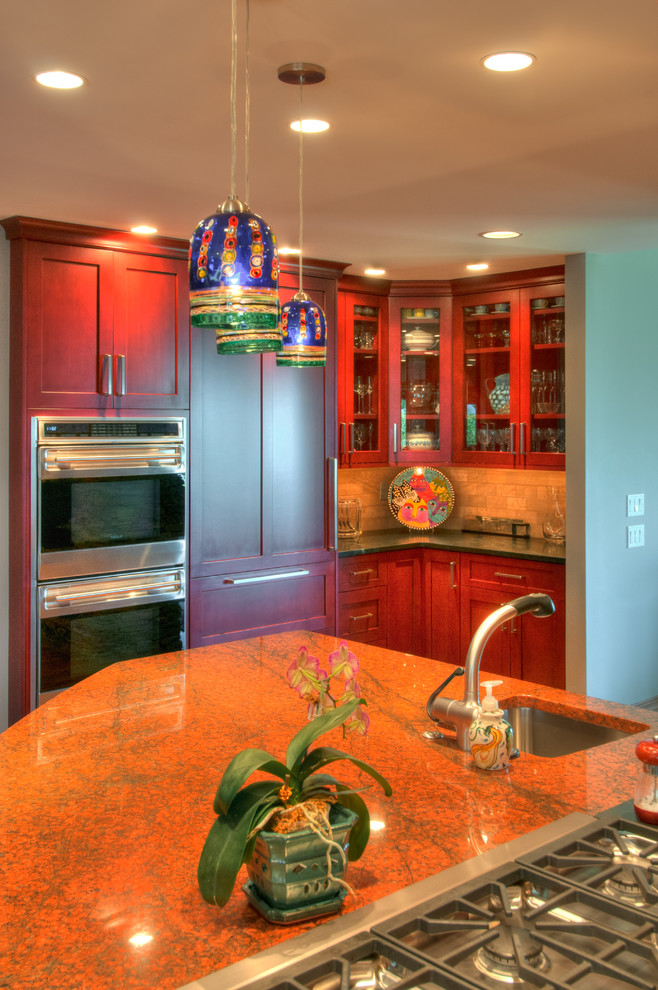 Large elegant l-shaped eat-in kitchen photo in Denver with an undermount sink, recessed-panel cabinets, red cabinets, granite countertops, beige backsplash, stone tile backsplash, stainless steel appliances and an island