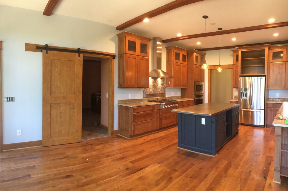 Exempel på ett amerikanskt kök och matrum, med en undermonterad diskho, skåp i shakerstil, skåp i mellenmörkt trä, granitbänkskiva, grått stänkskydd, stänkskydd i mosaik, rostfria vitvaror, mellanmörkt trägolv och en köksö