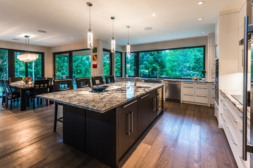 Minimalist kitchen photo in Vancouver with an undermount sink, flat-panel cabinets, white cabinets, granite countertops, gray backsplash, stainless steel appliances and an island