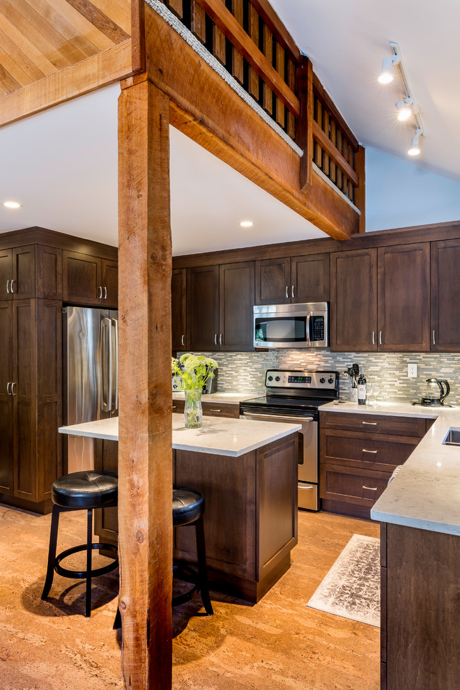Example of a large mountain style u-shaped light wood floor and brown floor open concept kitchen design in Vancouver with a drop-in sink, shaker cabinets, brown cabinets, marble countertops, gray backsplash, ceramic backsplash, stainless steel appliances, an island and white countertops