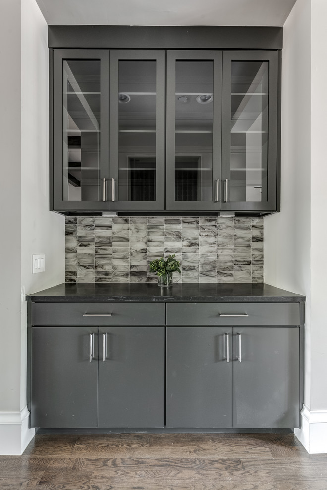 Example of a trendy u-shaped dark wood floor and brown floor open concept kitchen design in Dallas with an undermount sink, shaker cabinets, blue cabinets, quartz countertops, gray backsplash, ceramic backsplash, stainless steel appliances, an island and black countertops