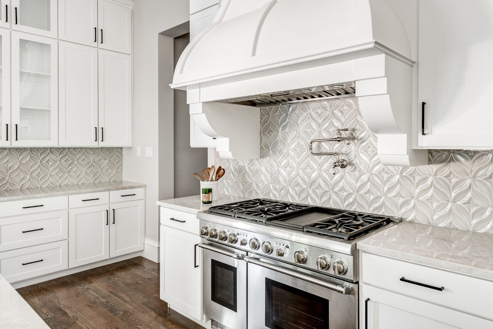 Inspiration for a large mediterranean u-shaped medium tone wood floor and brown floor open concept kitchen remodel in Dallas with a drop-in sink, shaker cabinets, white cabinets, quartzite countertops, beige backsplash, ceramic backsplash, stainless steel appliances, an island and beige countertops