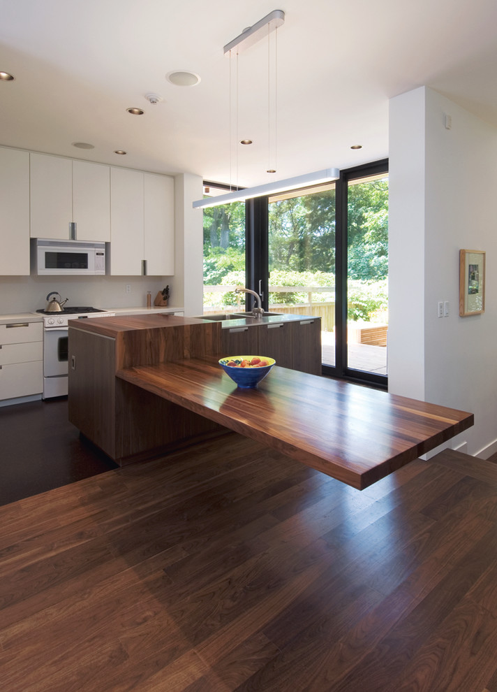Immagine di una cucina abitabile contemporanea con ante lisce e elettrodomestici bianchi