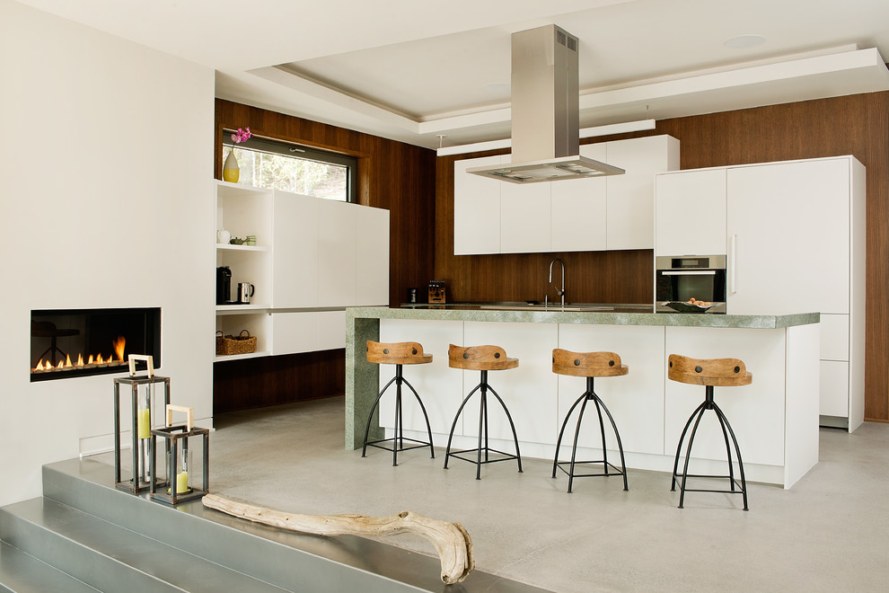 Esempio di una grande cucina minimal con ante lisce, ante bianche, elettrodomestici in acciaio inossidabile e pavimento in cemento