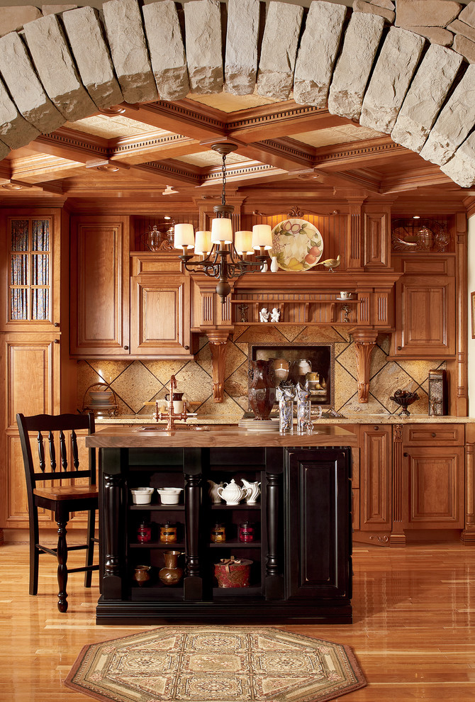 Example of a classic medium tone wood floor kitchen design in Other with raised-panel cabinets, medium tone wood cabinets, granite countertops, black backsplash, porcelain backsplash and an island