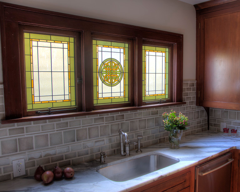 Exempel på ett avskilt, mellanstort klassiskt u-kök, med en undermonterad diskho, luckor med infälld panel, skåp i mörkt trä, marmorbänkskiva, grått stänkskydd, stänkskydd i keramik, rostfria vitvaror och cementgolv