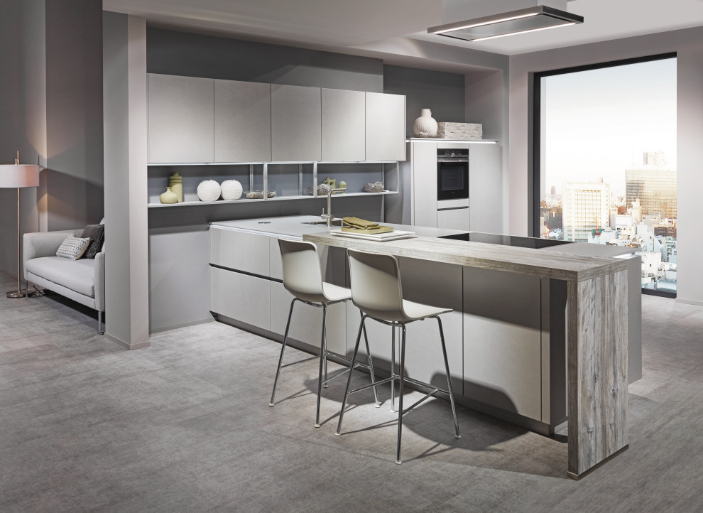 Medium sized contemporary l-shaped open plan kitchen in Dublin with flat-panel cabinets and an island.