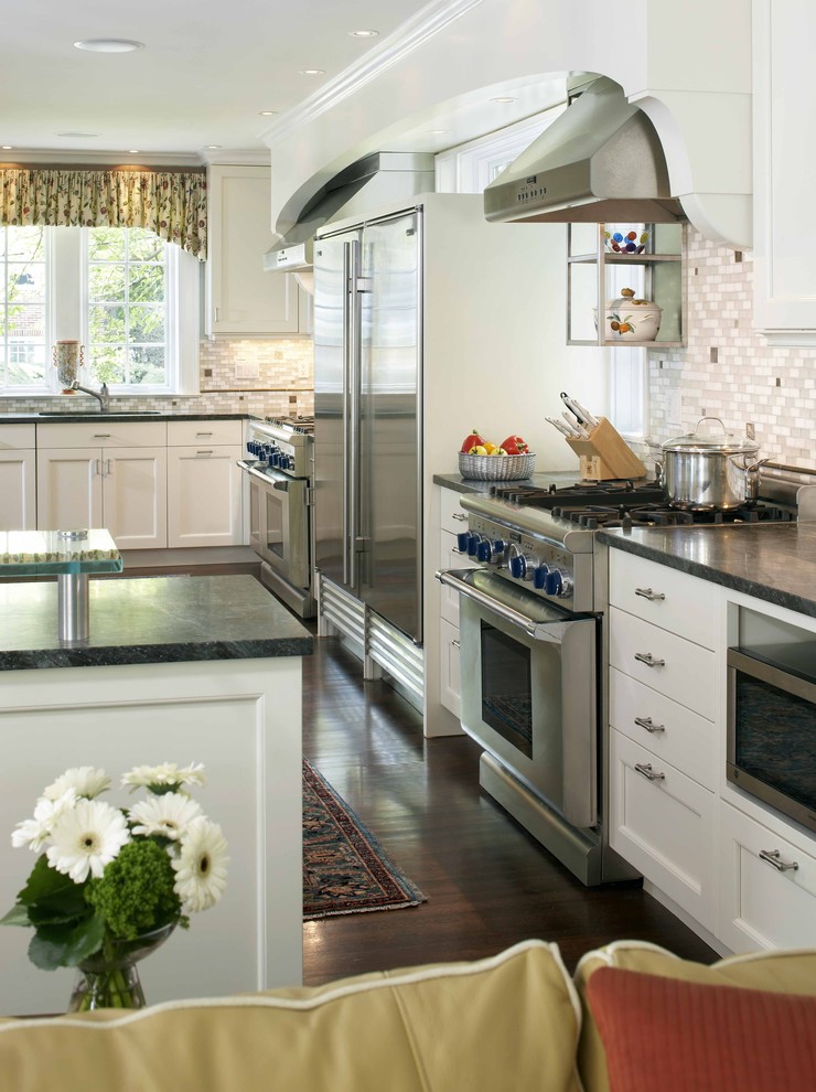 Kitchen - traditional l-shaped kitchen idea in Boston with soapstone countertops, stainless steel appliances, white cabinets and gray backsplash