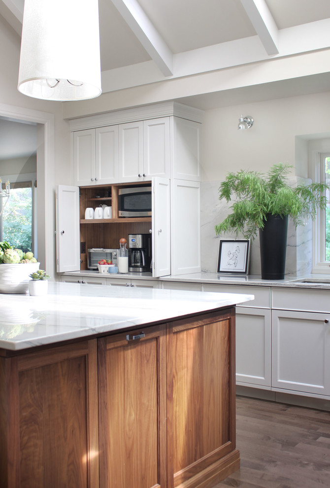Inspiration for a mid-sized transitional u-shaped medium tone wood floor eat-in kitchen remodel in Omaha with a double-bowl sink, shaker cabinets, white cabinets, quartzite countertops, white backsplash, stainless steel appliances, an island and white countertops
