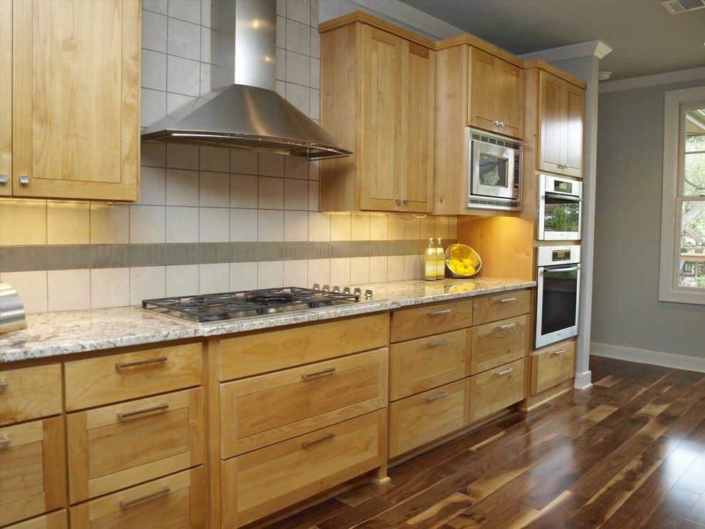 Exempel på ett stort modernt kök, med en undermonterad diskho, luckor med upphöjd panel, skåp i ljust trä, granitbänkskiva, rostfria vitvaror, mörkt trägolv och en köksö