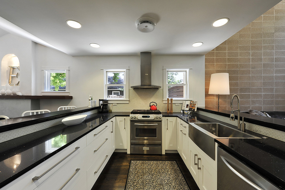 Ejemplo de cocina clásica renovada con electrodomésticos de acero inoxidable, fregadero sobremueble y barras de cocina