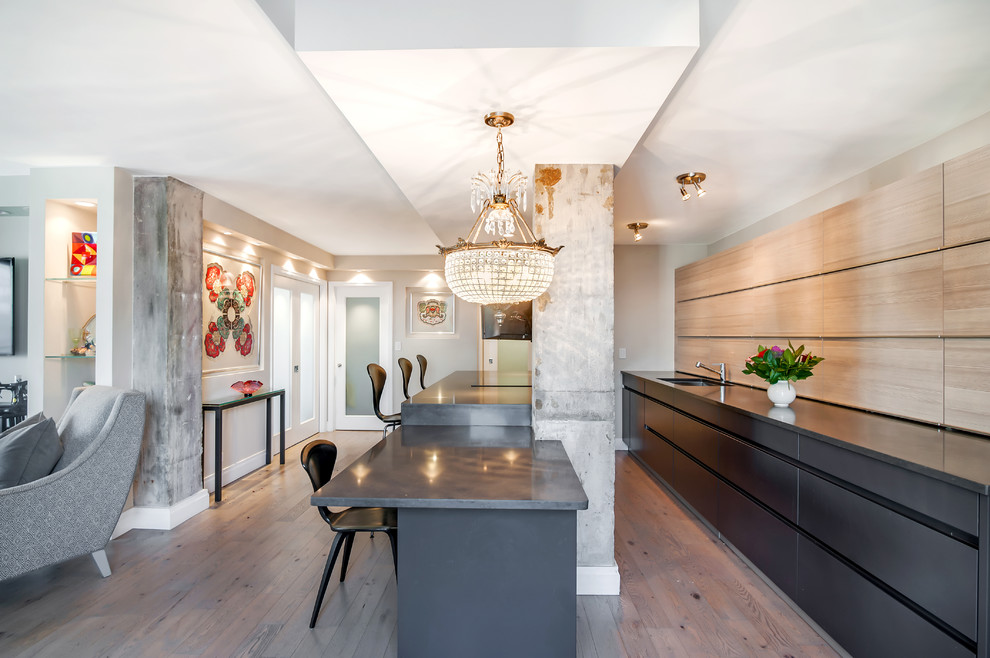 Example of a small trendy galley light wood floor eat-in kitchen design in New York with flat-panel cabinets, black cabinets, an island, an undermount sink, quartz countertops, paneled appliances and beige backsplash