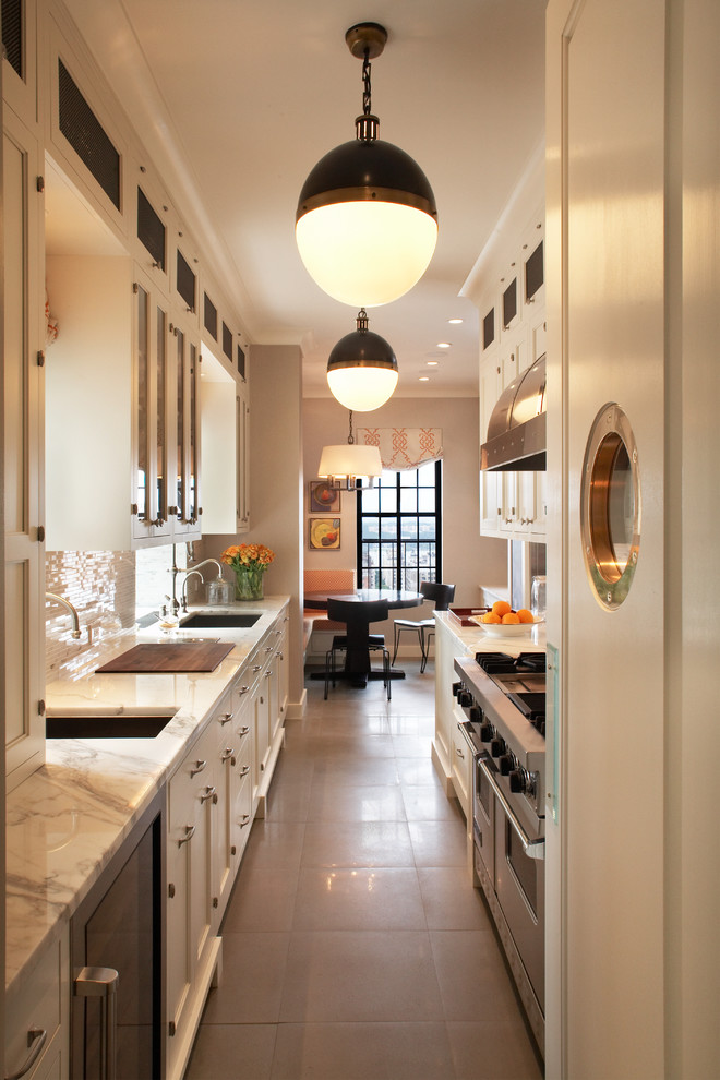 Inspiration for a transitional galley enclosed kitchen remodel in New York with glass-front cabinets, marble countertops and stainless steel appliances