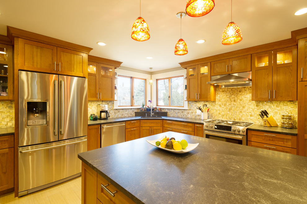 Large trendy l-shaped vinyl floor enclosed kitchen photo in Boston with a single-bowl sink, shaker cabinets, medium tone wood cabinets, soapstone countertops, multicolored backsplash, mosaic tile backsplash, stainless steel appliances and a peninsula