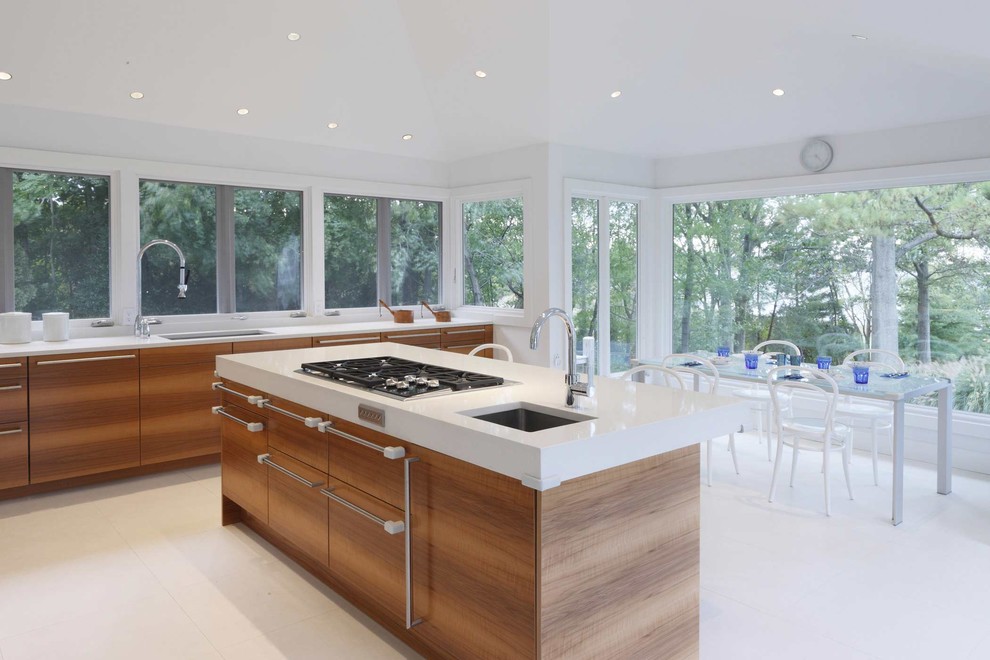 This is an example of a contemporary kitchen/diner in New York with a submerged sink, flat-panel cabinets, medium wood cabinets, marble worktops, white splashback, integrated appliances, marble flooring and white floors.