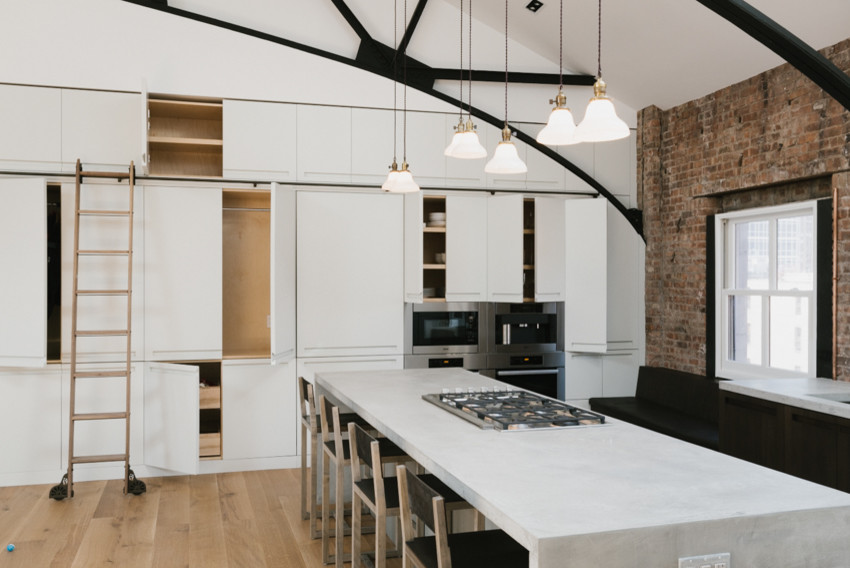 Example of a mid-sized minimalist open concept kitchen design in New York with concrete countertops and an island