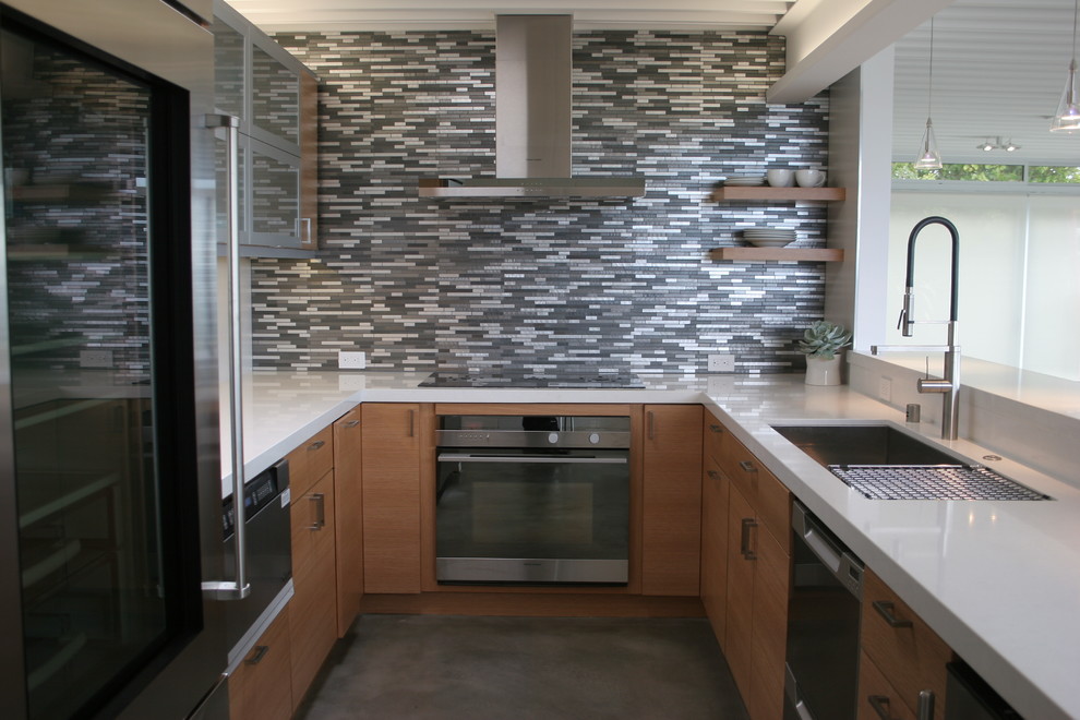 Inspiration for a small contemporary u-shaped concrete floor enclosed kitchen remodel in San Francisco with a double-bowl sink, flat-panel cabinets, medium tone wood cabinets, quartz countertops, multicolored backsplash, matchstick tile backsplash, stainless steel appliances and no island