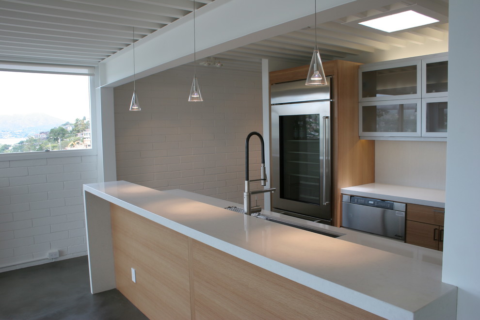 Example of a small trendy u-shaped concrete floor enclosed kitchen design in San Francisco with a double-bowl sink, flat-panel cabinets, medium tone wood cabinets, quartz countertops, multicolored backsplash, matchstick tile backsplash, stainless steel appliances and no island