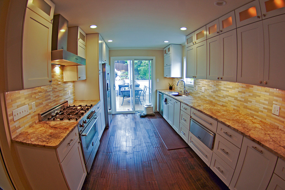 Modern inredning av ett stort kök, med en undermonterad diskho, luckor med infälld panel, bänkskiva i onyx, flerfärgad stänkskydd, rostfria vitvaror och mörkt trägolv