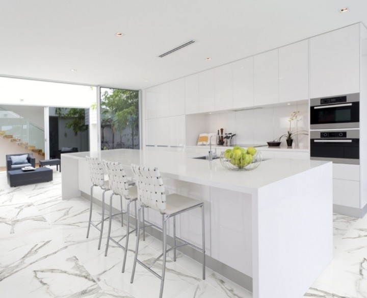 Große Moderne Küche mit weißen Schränken, Quarzwerkstein-Arbeitsplatte, Rückwand aus Steinfliesen, Küchengeräten aus Edelstahl und Porzellan-Bodenfliesen in Toronto