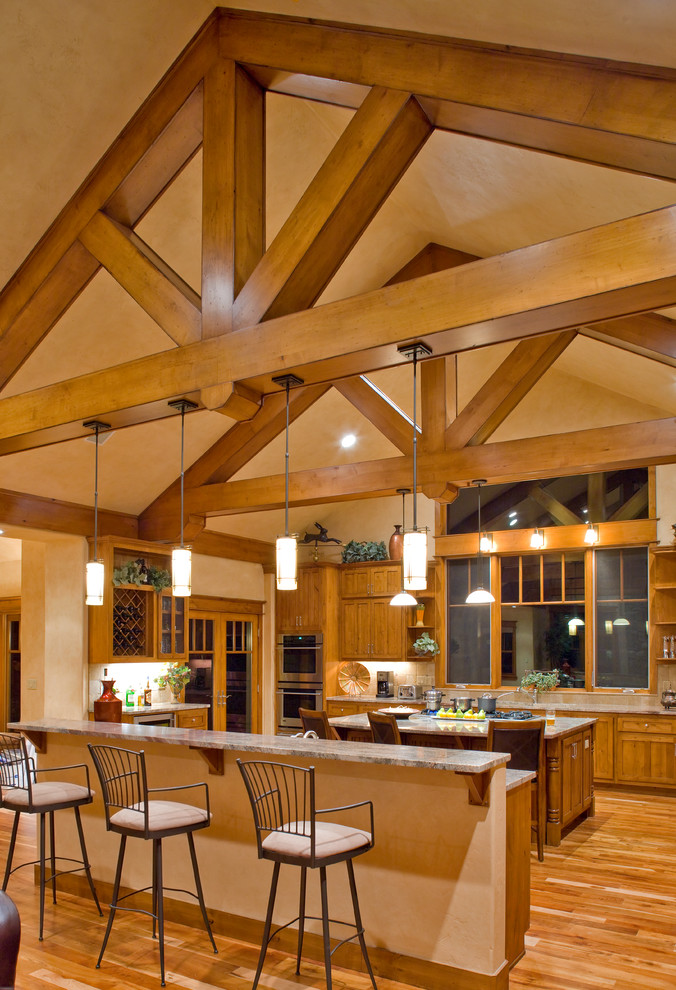 Große Rustikale Wohnküche mit hellbraunen Holzschränken, Küchengeräten aus Edelstahl, braunem Holzboden und zwei Kücheninseln in Albuquerque