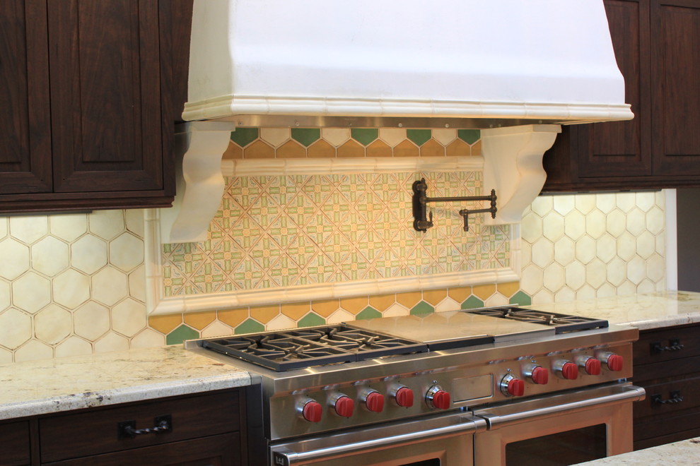 Example of a huge tuscan u-shaped terra-cotta tile open concept kitchen design in San Diego with a farmhouse sink, distressed cabinets, granite countertops, multicolored backsplash, paneled appliances, recessed-panel cabinets, terra-cotta backsplash and an island