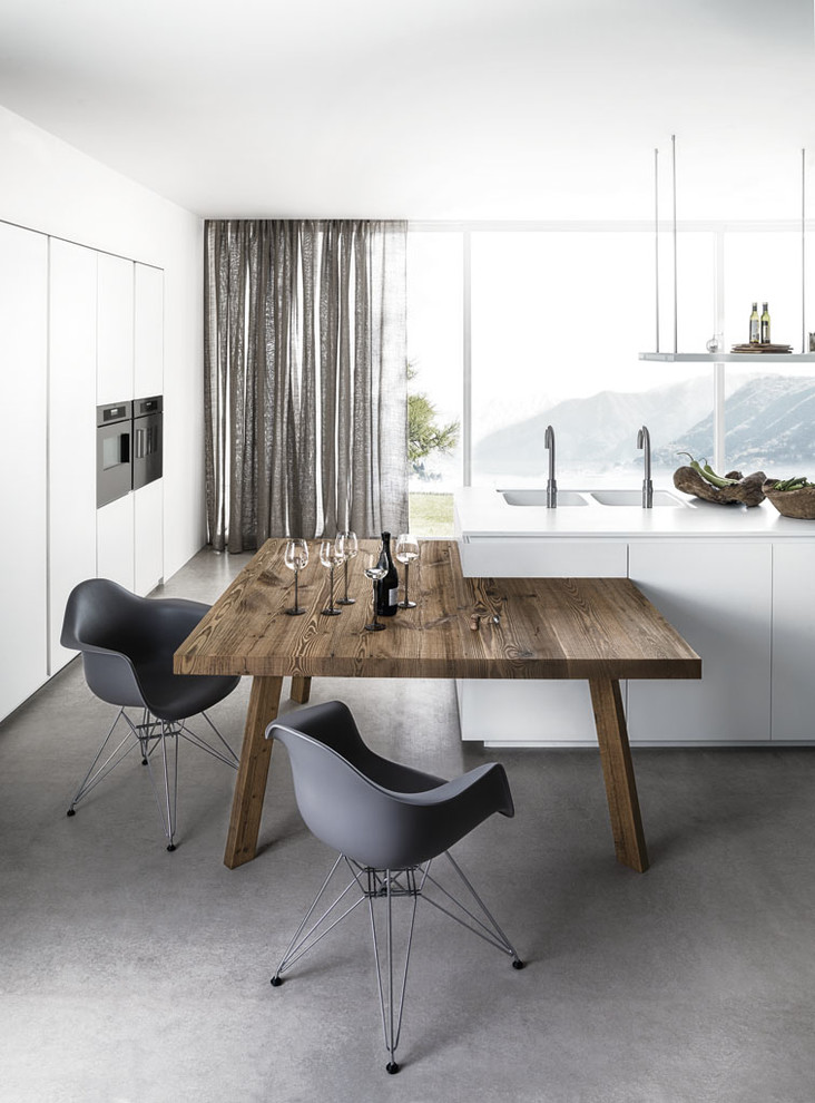 На фото: большая угловая кухня в стиле модернизм с обеденным столом, серыми фасадами, деревянной столешницей, черной техникой и островом с