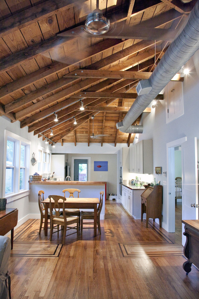 Example of a classic eat-in kitchen design in Charleston with white cabinets and wood countertops