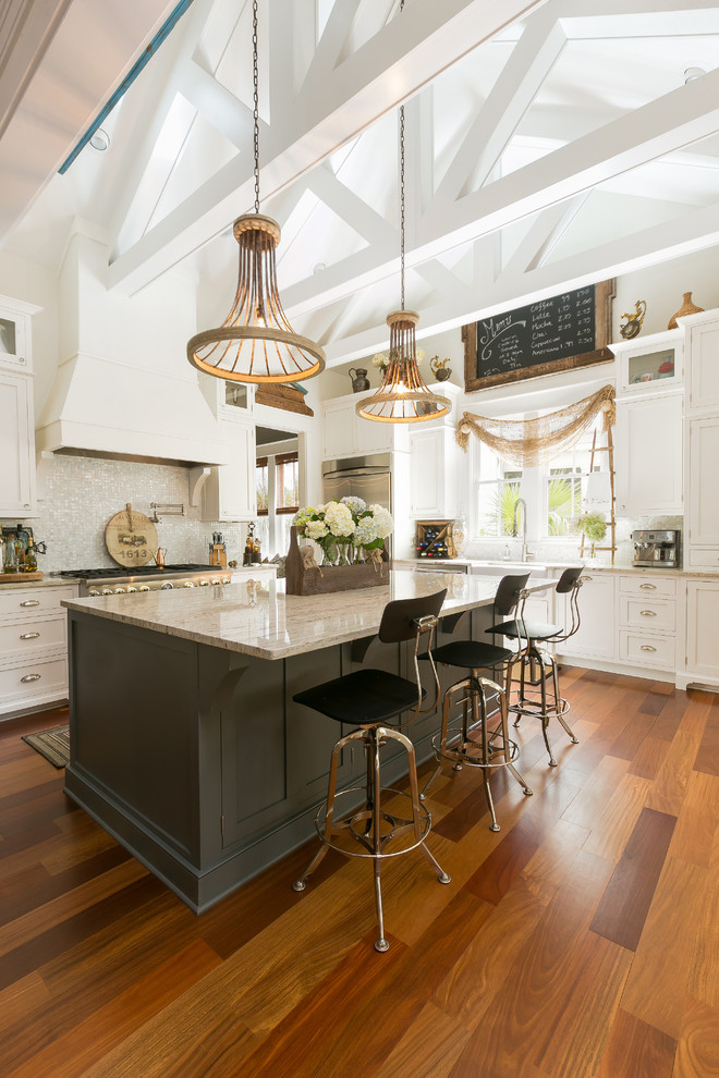 Country Küche mit Schrankfronten im Shaker-Stil, weißen Schränken, Rückwand aus Mosaikfliesen, braunem Holzboden, Kücheninsel und bunter Rückwand in Charleston