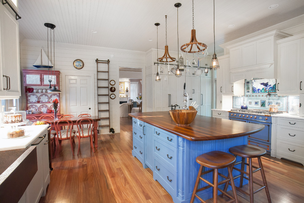 Maritime Wohnküche mit bunten Elektrogeräten, braunem Holzboden, Kücheninsel, Schrankfronten im Shaker-Stil, blauen Schränken und Arbeitsplatte aus Holz in Charleston