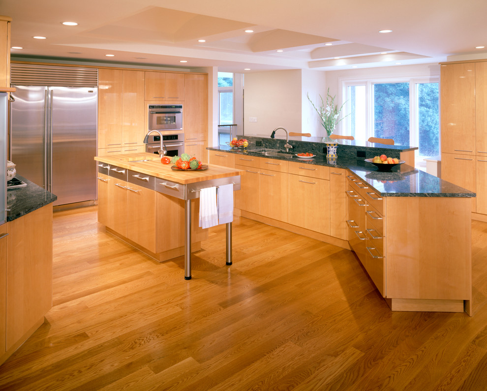 Foto di una cucina minimal con ante lisce e ante in legno chiaro