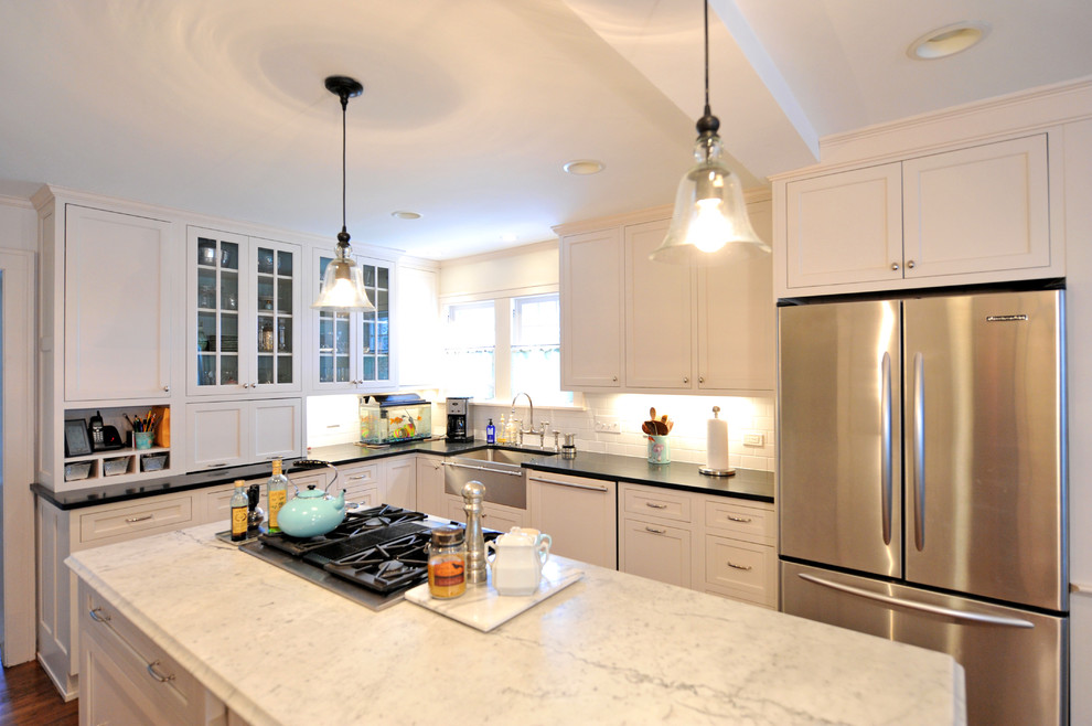Eat-in kitchen - large contemporary u-shaped medium tone wood floor eat-in kitchen idea in Cleveland with an undermount sink, shaker cabinets, white cabinets, marble countertops, white backsplash, subway tile backsplash, stainless steel appliances and an island
