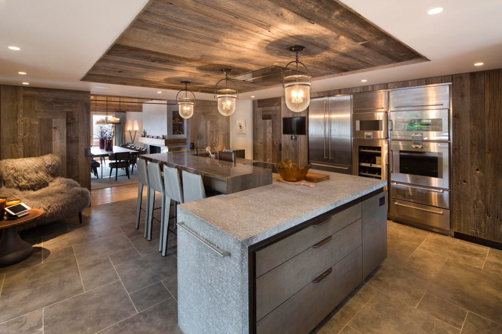 ラスティックスタイルのおしゃれなキッチン (フラットパネル扉のキャビネット、中間色木目調キャビネット、シルバーの調理設備、グレーの床、グレーのキッチンカウンター、板張り天井) の写真