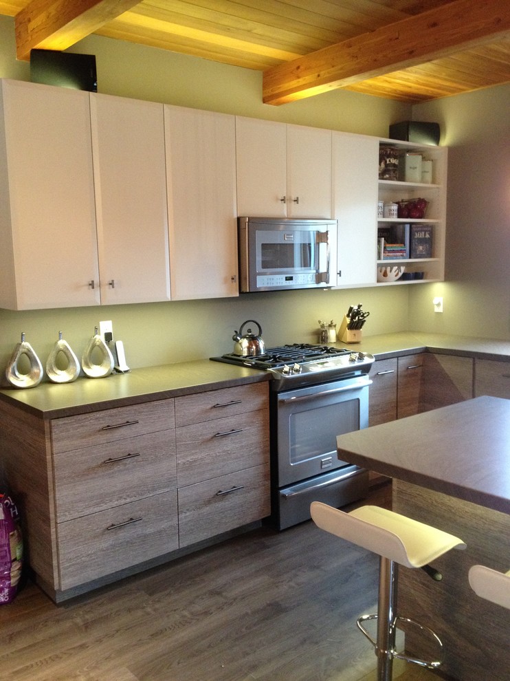 Immagine di una cucina design con lavello sottopiano, ante lisce, ante in legno chiaro, top in laminato e elettrodomestici in acciaio inossidabile