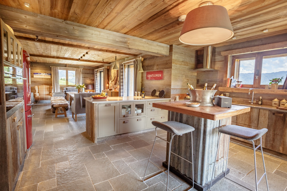 Design ideas for a rustic open plan kitchen in London with a submerged sink, brown cabinets, coloured appliances, an island and brown floors.