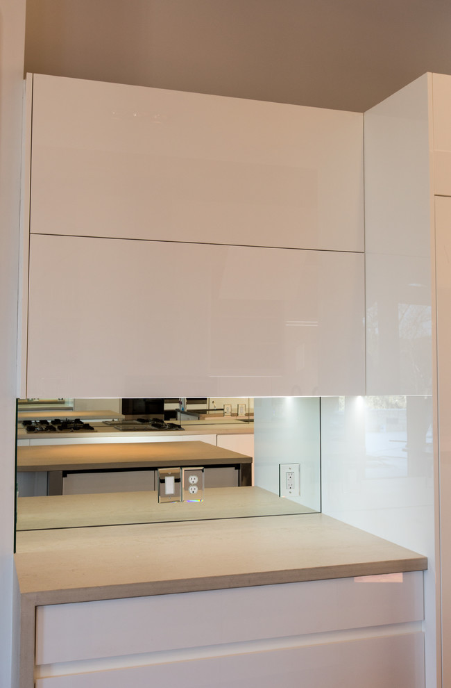 Exemple d'une grande cuisine américaine moderne en U avec un évier encastré, un placard à porte plane, des portes de placard blanches, une crédence blanche, parquet foncé, une crédence miroir et îlot.