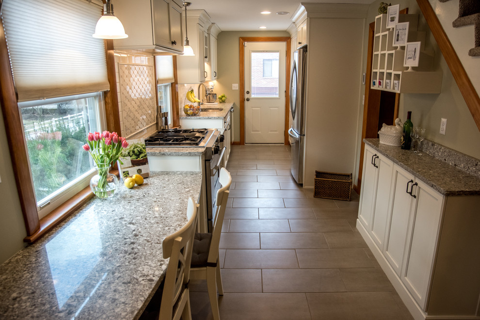 Inspiration for a small classic galley enclosed kitchen in Boston with a submerged sink, shaker cabinets, white cabinets, engineered stone countertops, white splashback, metro tiled splashback, stainless steel appliances and porcelain flooring.
