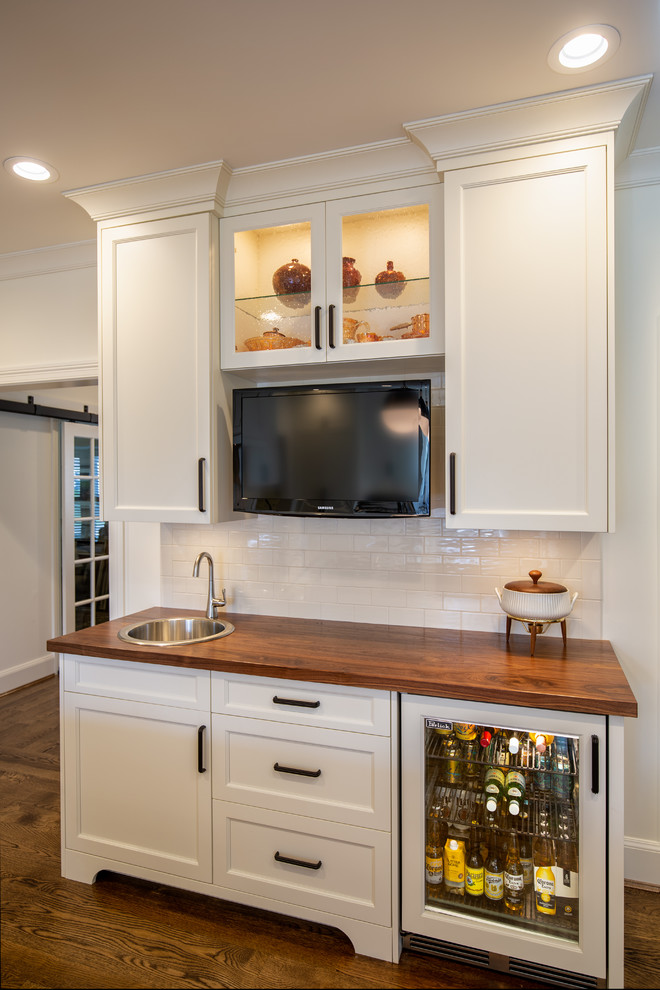Inspiration for a transitional medium tone wood floor kitchen remodel in Cincinnati with an undermount sink, shaker cabinets, white cabinets, wood countertops, white backsplash, porcelain backsplash, stainless steel appliances, an island and multicolored countertops