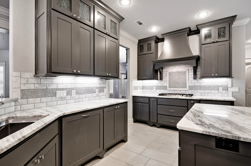 Example of a large classic l-shaped porcelain tile and gray floor kitchen design in Other with shaker cabinets, dark wood cabinets, marble countertops, white backsplash, stone tile backsplash, stainless steel appliances, an island and an undermount sink